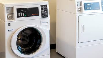 Two white front-loading washing machines with digital displays and control panels.