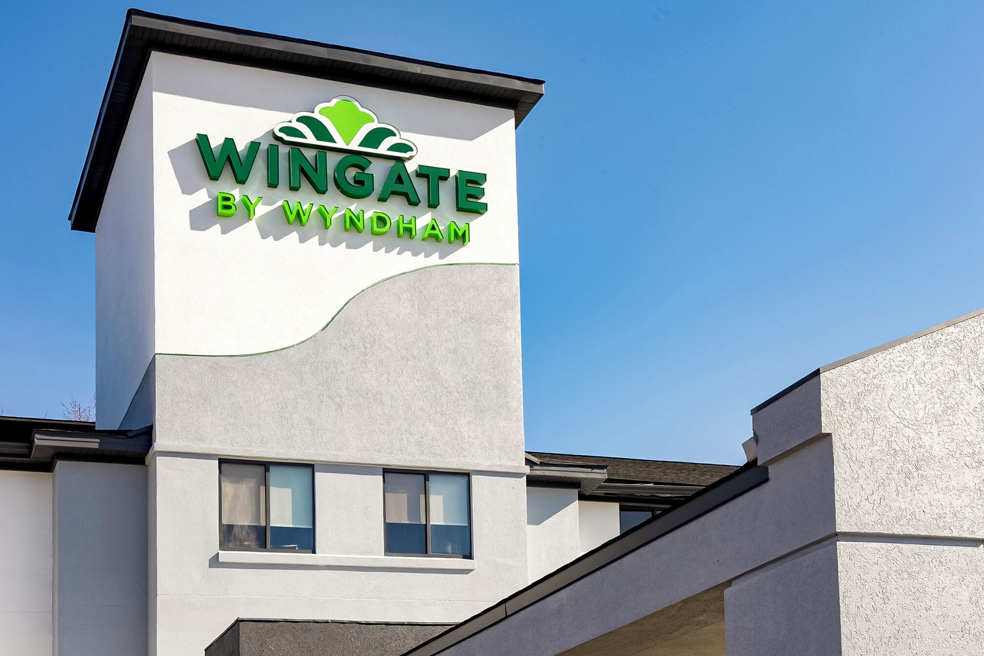 A building with a sign that reads "Wingate by Wyndham" on the side.