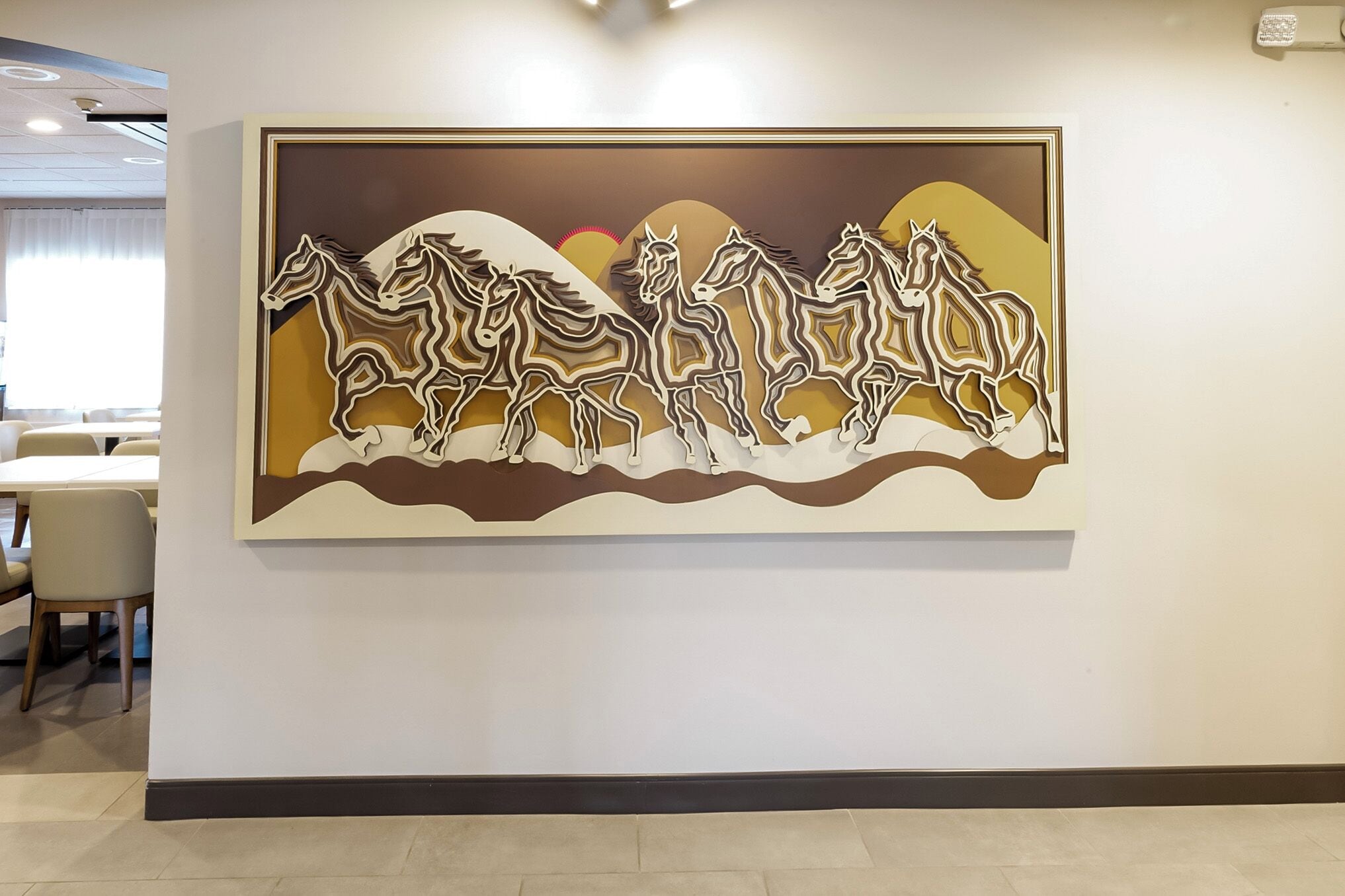 Una pared con una obra de arte abstracta de gran tamaño que representa caballos.