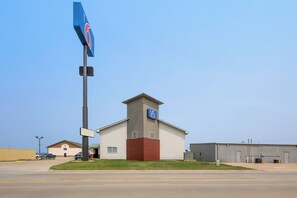 A motel with a prominent '6' sign, a central tower, and a large parking lot. - Motel 6 North Sioux City, SD I 29 North (North Sioux City)