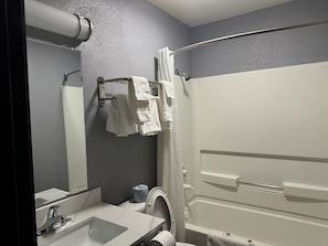 Bathroom features a sink, shower, and towel rack.