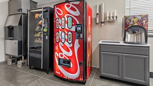 Ett område med försäljningsautomater, inklusive en automat med Coca-Colas logotyp, en vattenautomat och en kaffemaskin.