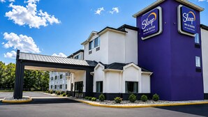 A Sleep Inn & Suites hotel with a modern design, featuring a prominent purple and white color scheme, a covered entrance, and a well-maintained parking area. - Sleep Inn & Suites Peoria North (Peoria)