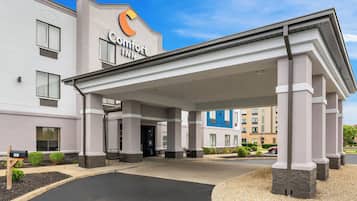 A Comfort Inn hotel with a covered entrance, multiple windows, and a clear sky.