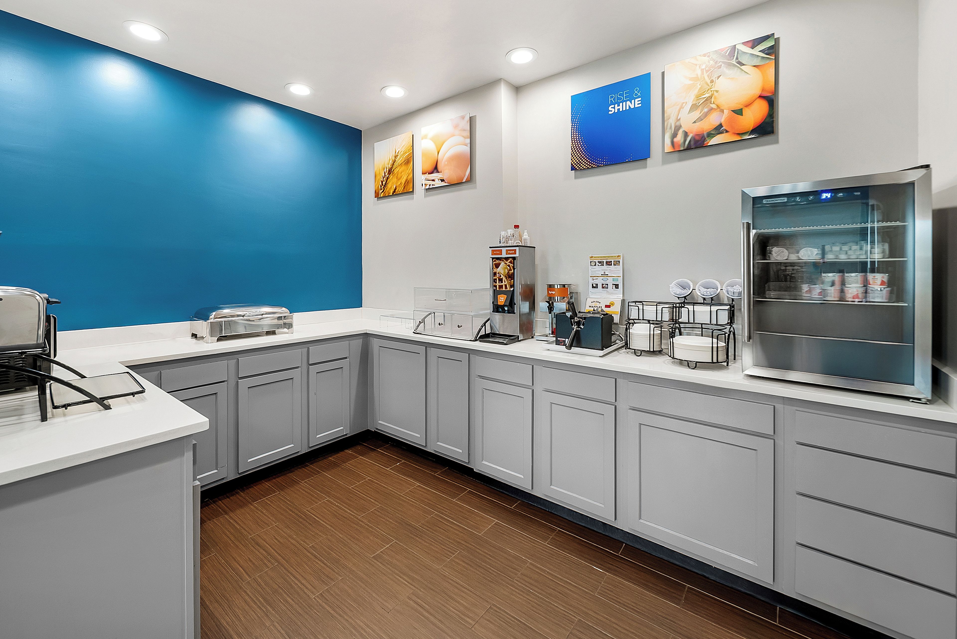 Una cocina moderna con armarios grises, un refrigerador de acero inoxidable y una pared de acento azul.