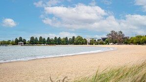 A beach with a sandy shore, a calm sea, and a clear sky with clouds. - DoubleTree by Hilton Hotel Boston Bayside (Boston)