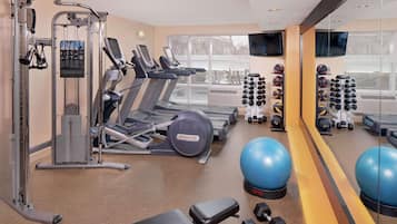 A gym with treadmills, weight machines, free weights, and exercise balls.