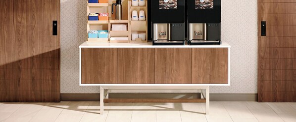 Een moderne keuken met een houten kast, een koffieapparaat en opbergdozen.