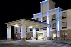 A hotel with a covered entrance, multiple floors, and a stone facade.
