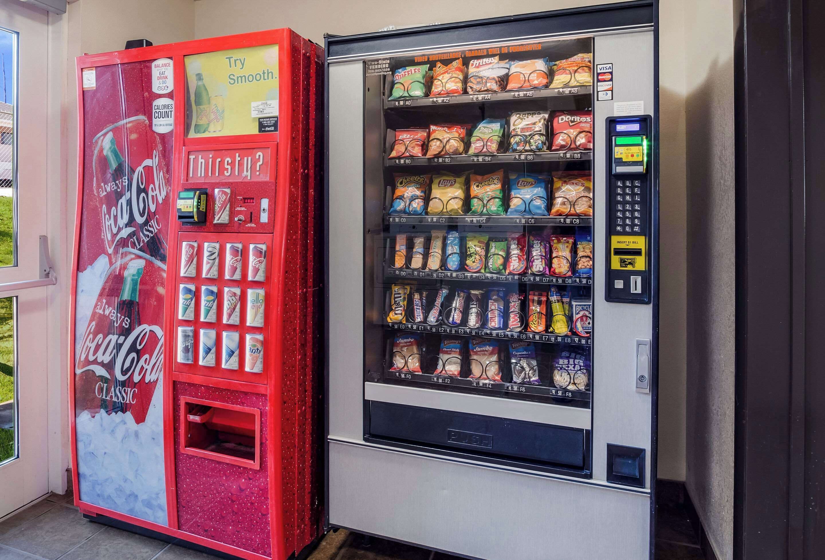 A vending machine with snacks and a Coca-Cola machine.
