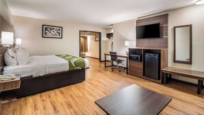A hotel room with a bed, desk, chair, TV, and a small dining table. - Quality Inn & Suites Augusta Fort Gordon Area (Augusta)