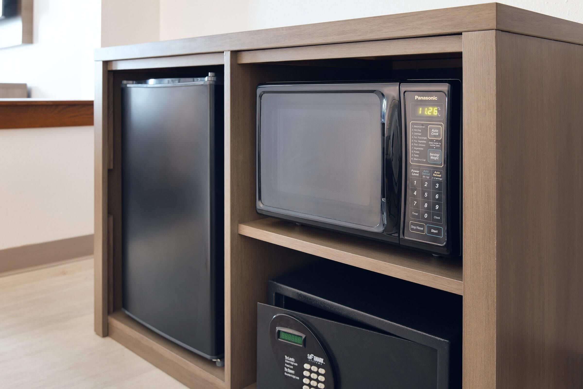 Cocina compacta con microondas, horno integrado y cafetera.