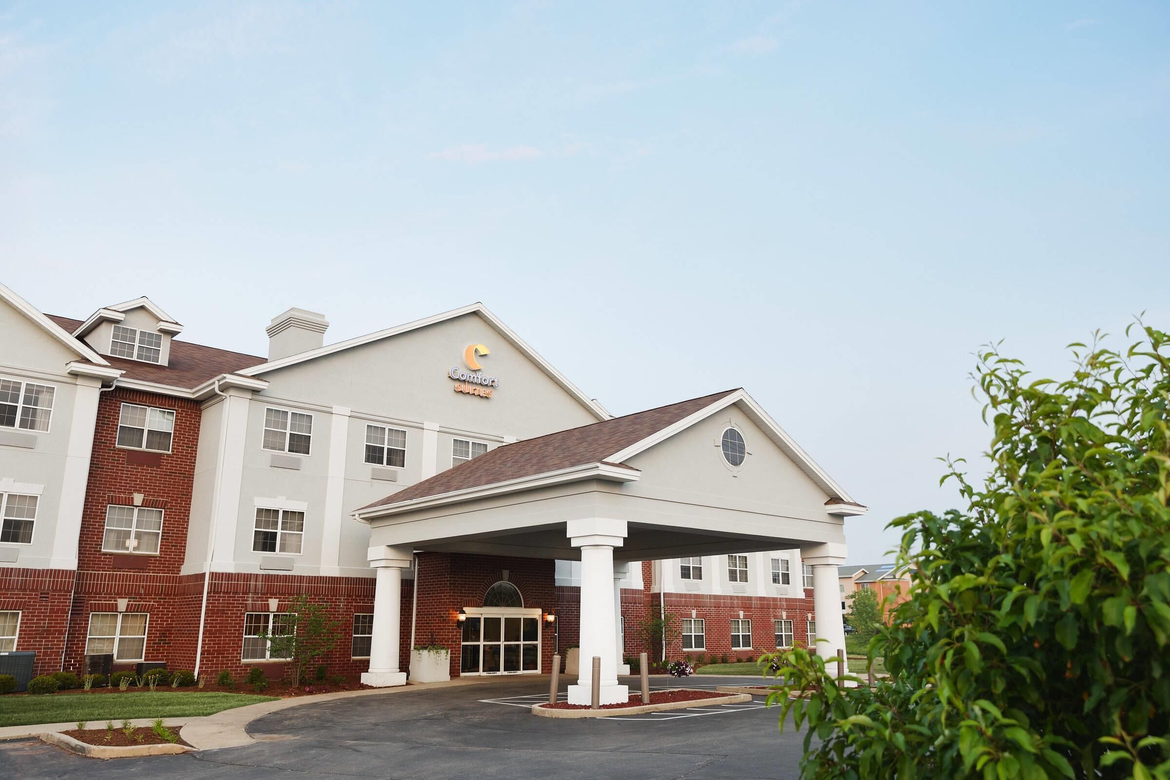 Un hotel de varios pisos con entrada cubierta, fachada de ladrillo y un cartel que indica que es un Comfort Inn.