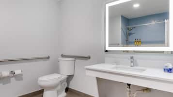 Un baño moderno con inodoro, lavabo y espejo.