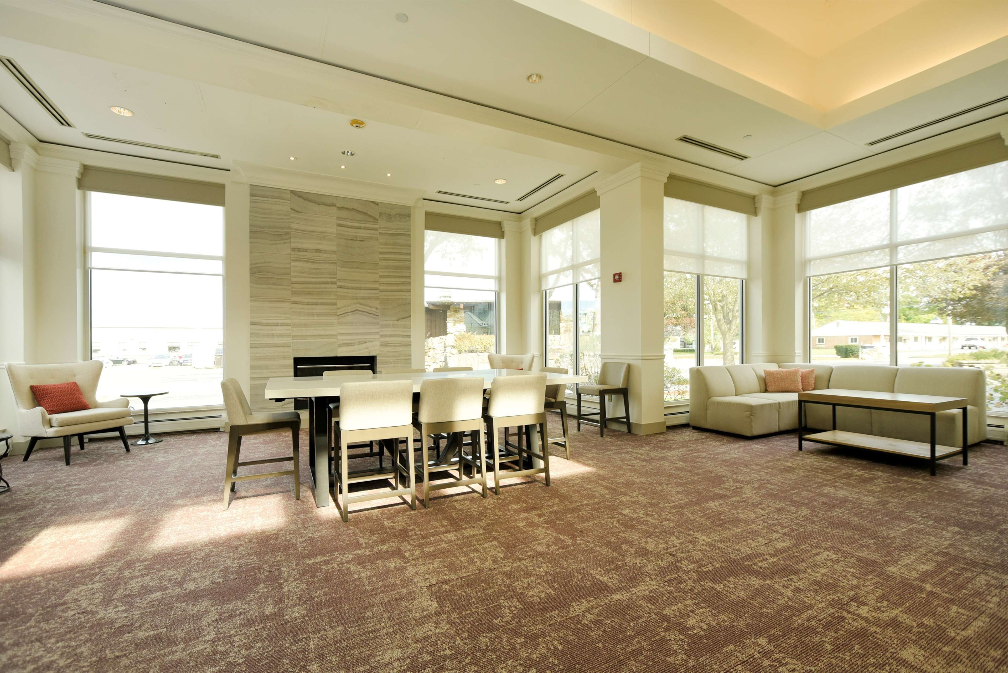 A spacious room with a large dining table, multiple chairs, a sofa, and a coffee table.