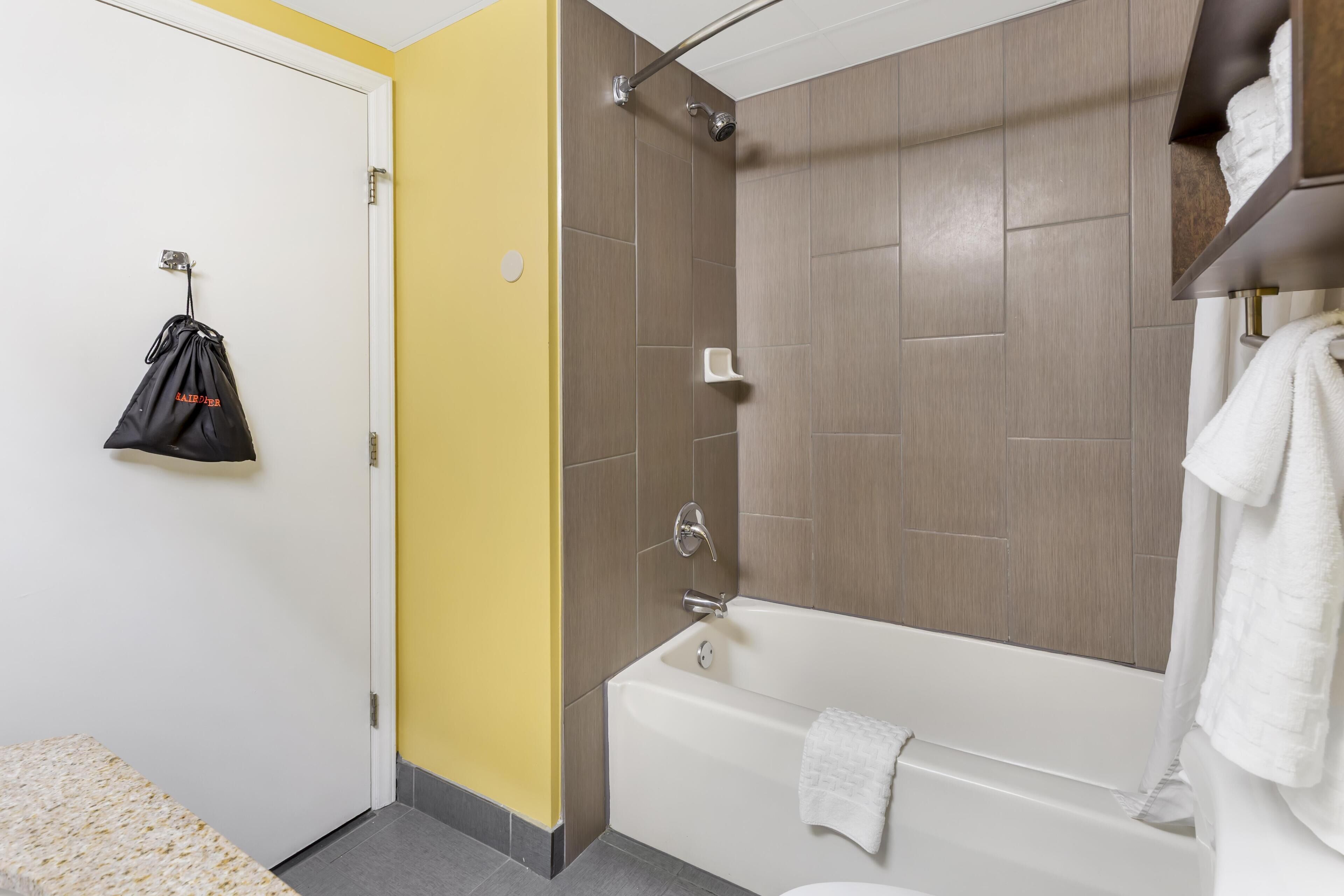 Un baño con bañera, ducha e inodoro.