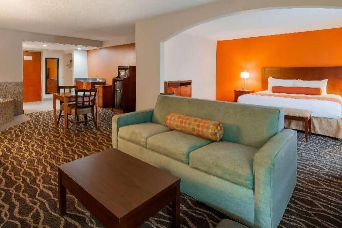 Une chambre d’hôtel équipée d’un canapé, d’une table basse, d’un lit et d’un bureau.