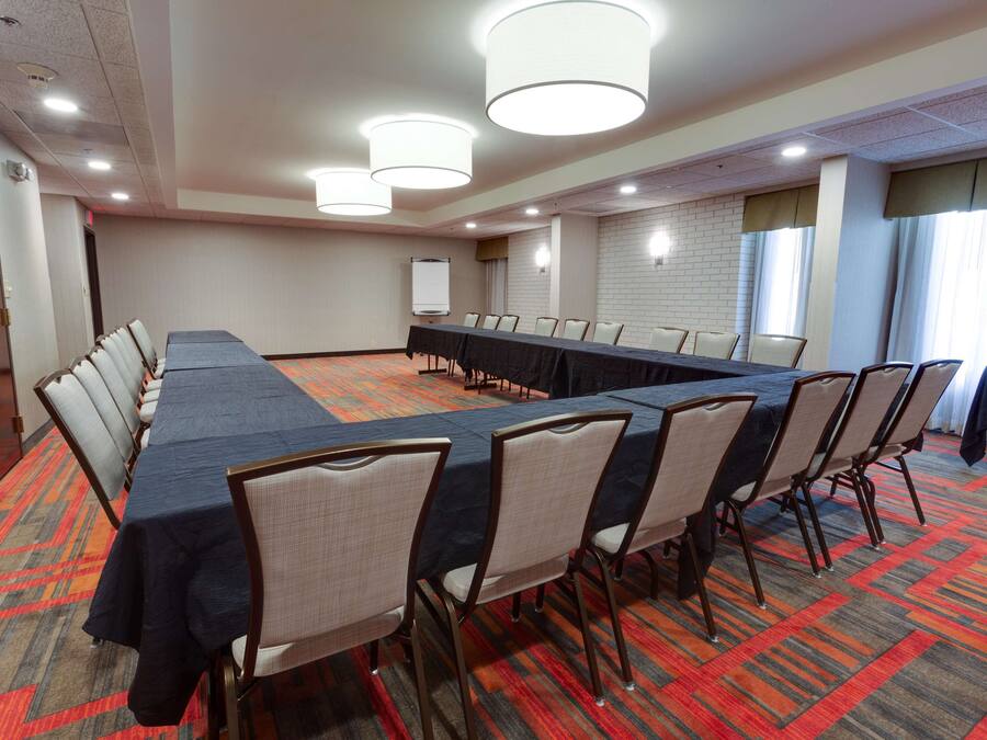 A conference room with a long table, chairs, and a whiteboard.