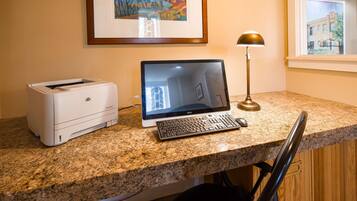 A desktop computer with a monitor, keyboard, and HP printer on a granite countertop.
