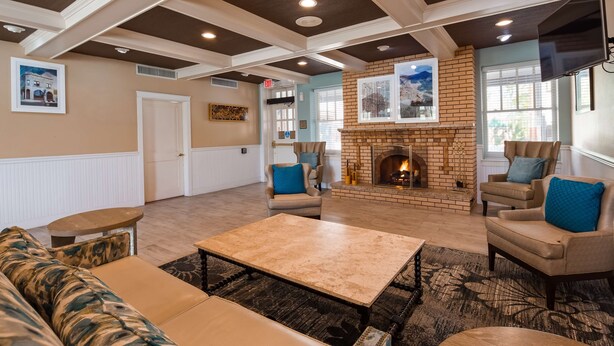 A spacious living room with a fireplace, leather sofas, and a coffee table. - Best Western Plus Plaza Hotel (Thermopolis)