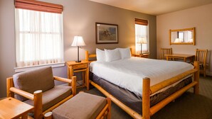 A hotel room with a large bed, wooden furniture, a desk, and a chair. - Best Western Plus Plaza Hotel (Thermopolis)