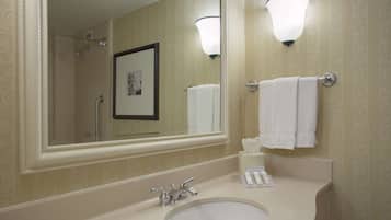 A bathroom with a sink, mirror, and towel rack.