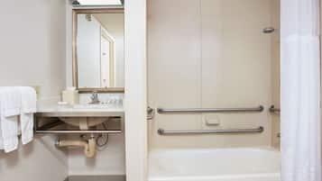 A bathroom with a bathtub, a sink, a mirror, and a shower curtain.