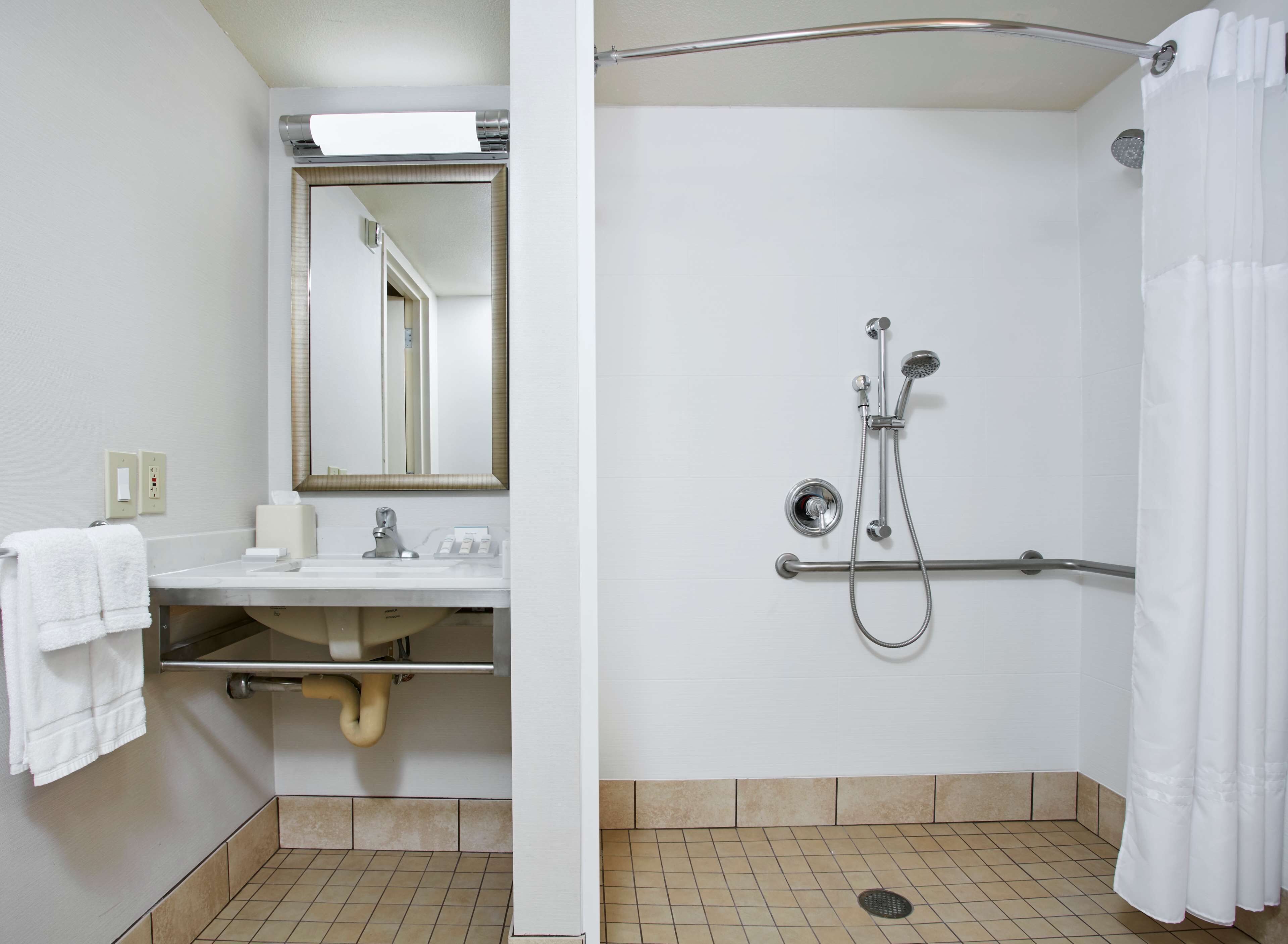 Ein Badezimmer mit Waschbecken, Spiegel und Dusche.