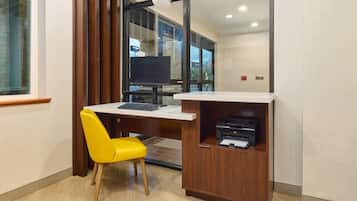 A small office area with a desk, a yellow chair, a computer, and a printer.