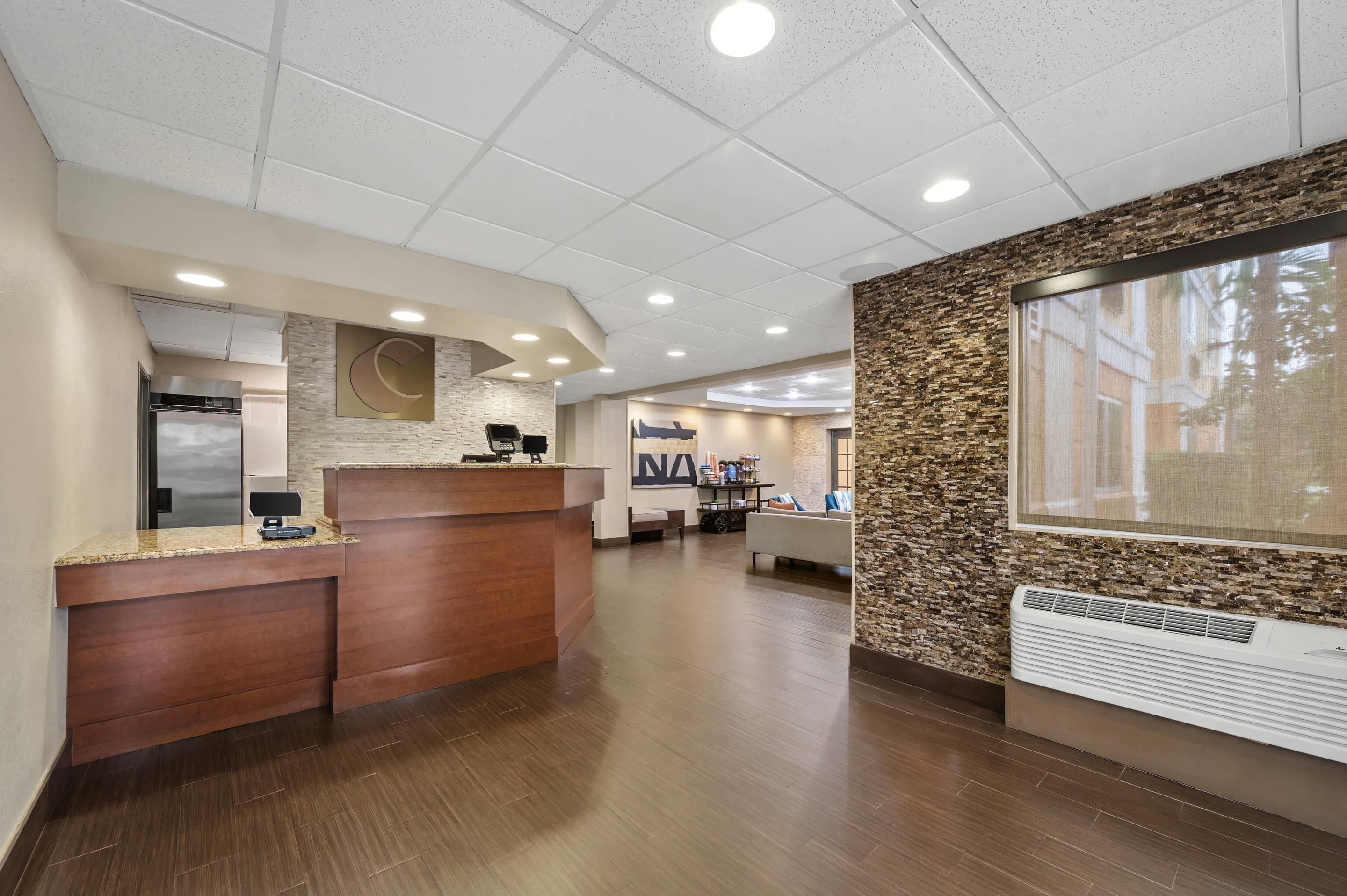 A reception area with a wooden reception desk, a large wall clock, and a reception counter.