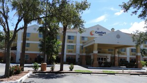 A Comfort Inn hotel with a covered entrance, multiple floors, and surrounding greenery. - Comfort Inn Fort Myers Northeast (Fort Myers)