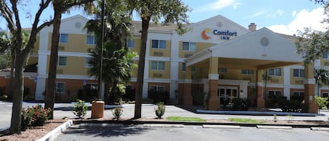 A Comfort Inn hotel with a covered entrance, multiple floors, and surrounding greenery.