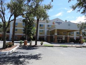 A Comfort Inn hotel with a covered entrance, multiple floors, and surrounding greenery. - Comfort Inn Fort Myers Northeast (Fort Myers)