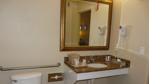 A bathroom with a toilet, sink, mirror, and hand dryer. - Comfort Inn Fort Myers Northeast (Fort Myers)