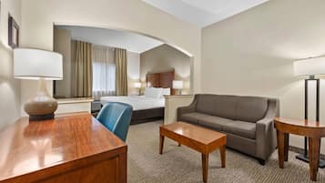 Una habitación de hotel con cama, sofá, escritorio y silla.