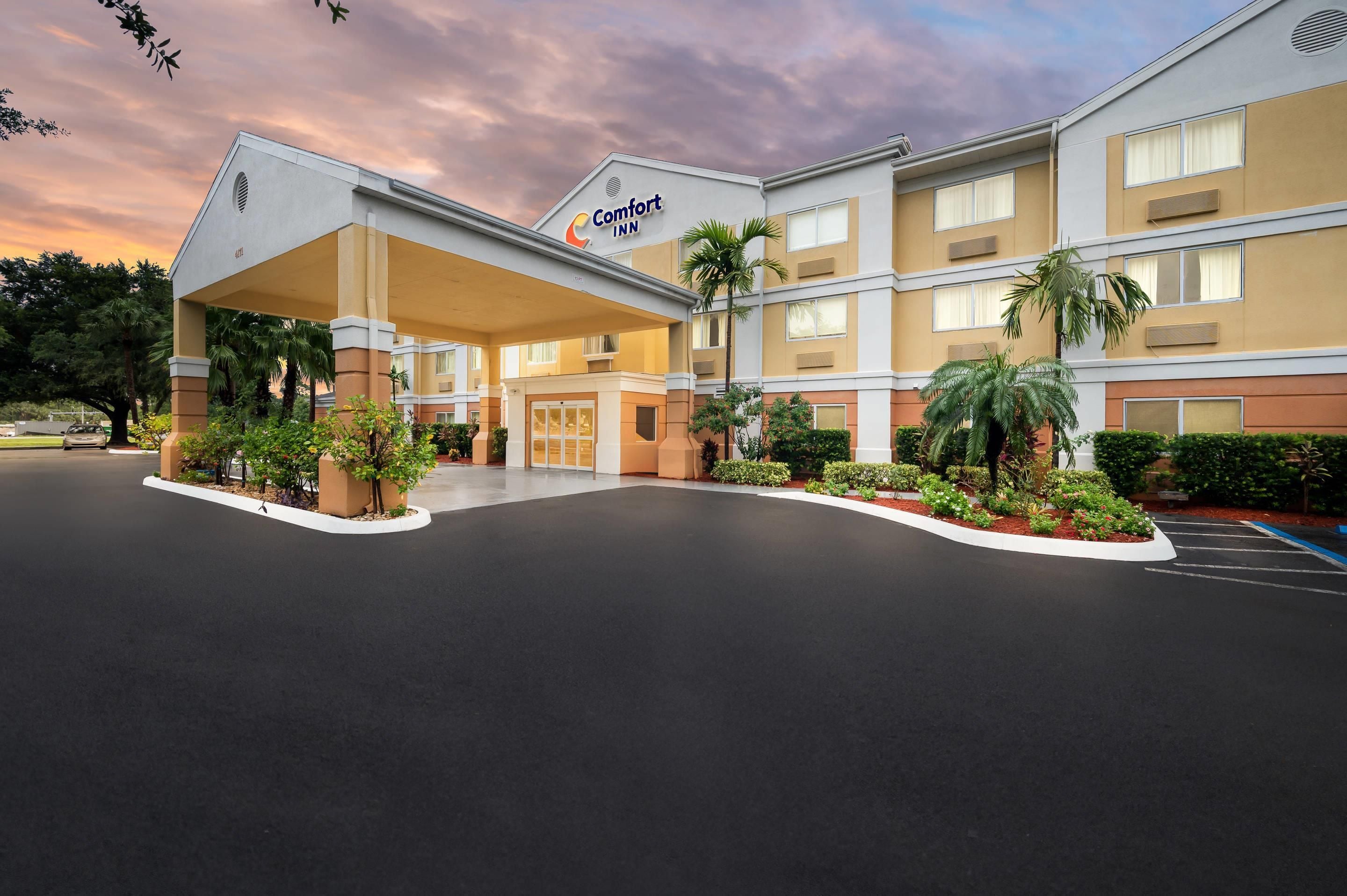 Ein Comfort Inn Hotel mit überdachter Zufahrt, mehreren Etagen und einem Parkplatz.