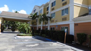 A hotel with a covered entrance, multiple floors, and a parking area with handicapped spaces. - Comfort Inn Fort Myers Northeast (Fort Myers)