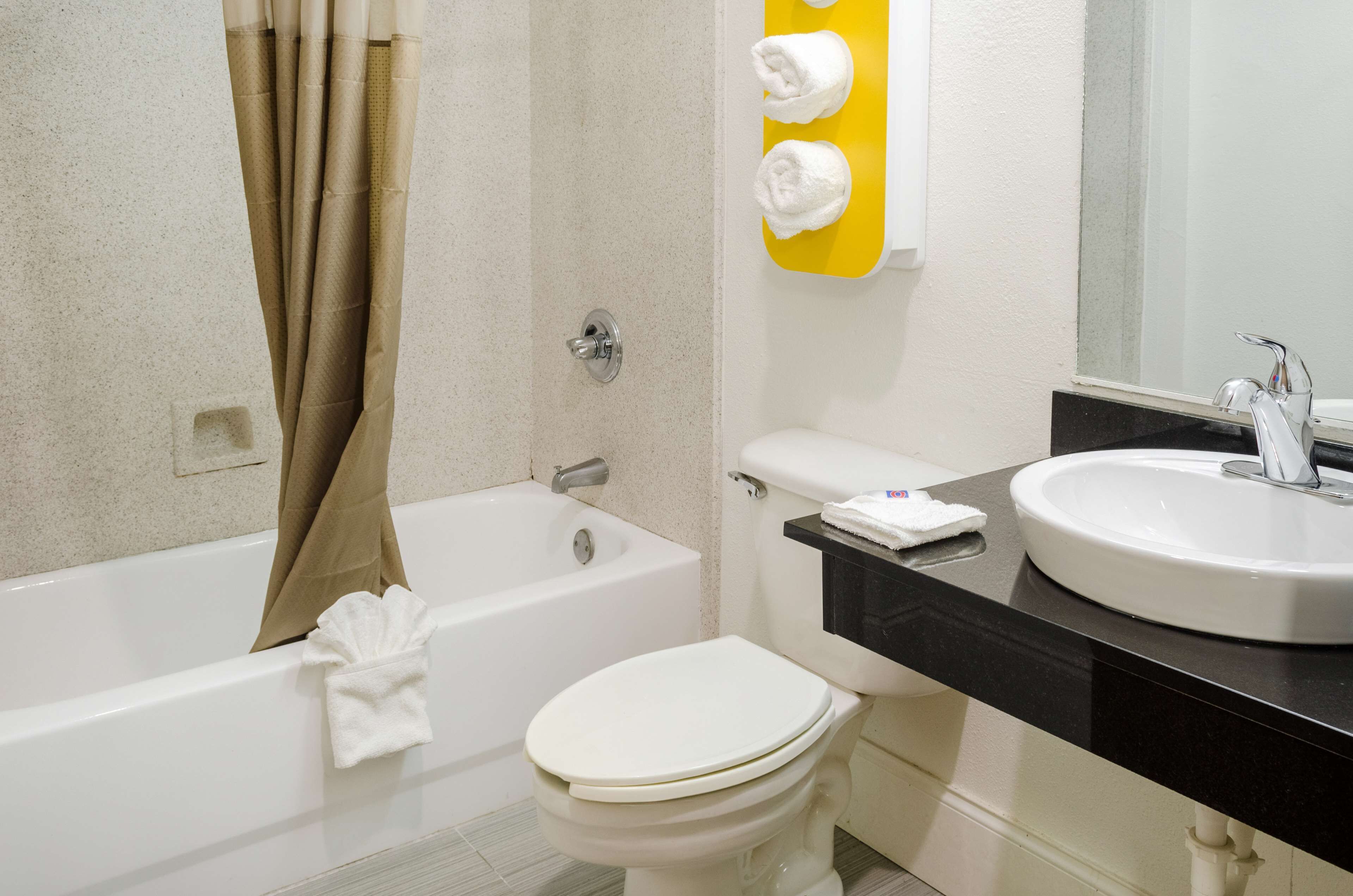 A bathroom with a bathtub, toilet, and sink.