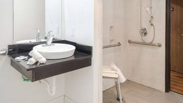 A bathroom with a white sink, mirror, and towel rack.