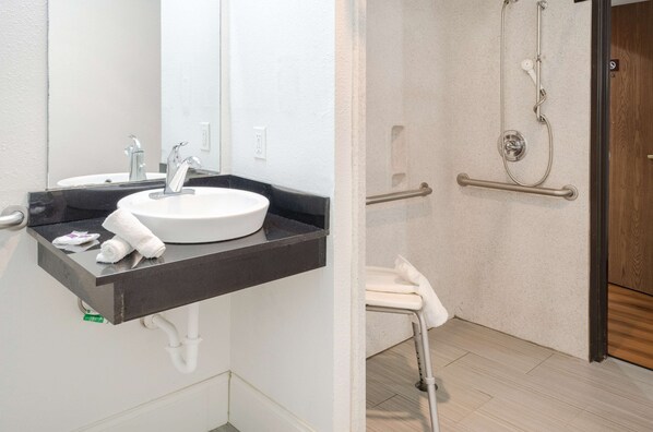 Une salle de bain avec un lavabo blanc, un miroir et un porte-serviettes.