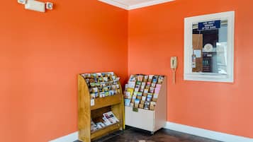 A corner with two bulletin boards displaying various pamphlets and a wall-mounted phone.