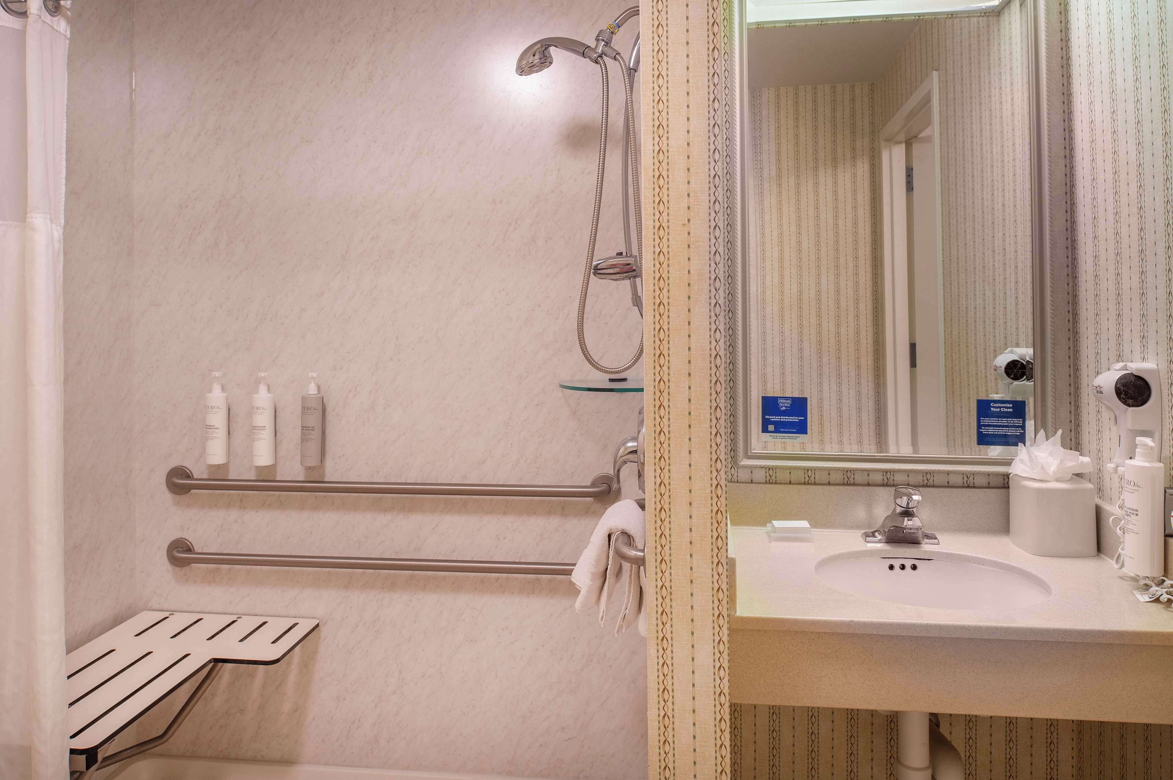 A bathroom with a shower, a sink, and toiletries.