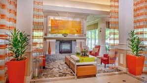 A spacious living area with a fireplace, a television mounted above it, and a comfortable seating arrangement.
