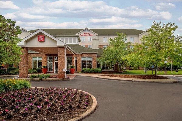 Enter a tranquil setting surrounded by lush greenery and a beautifully maintained lawn.
