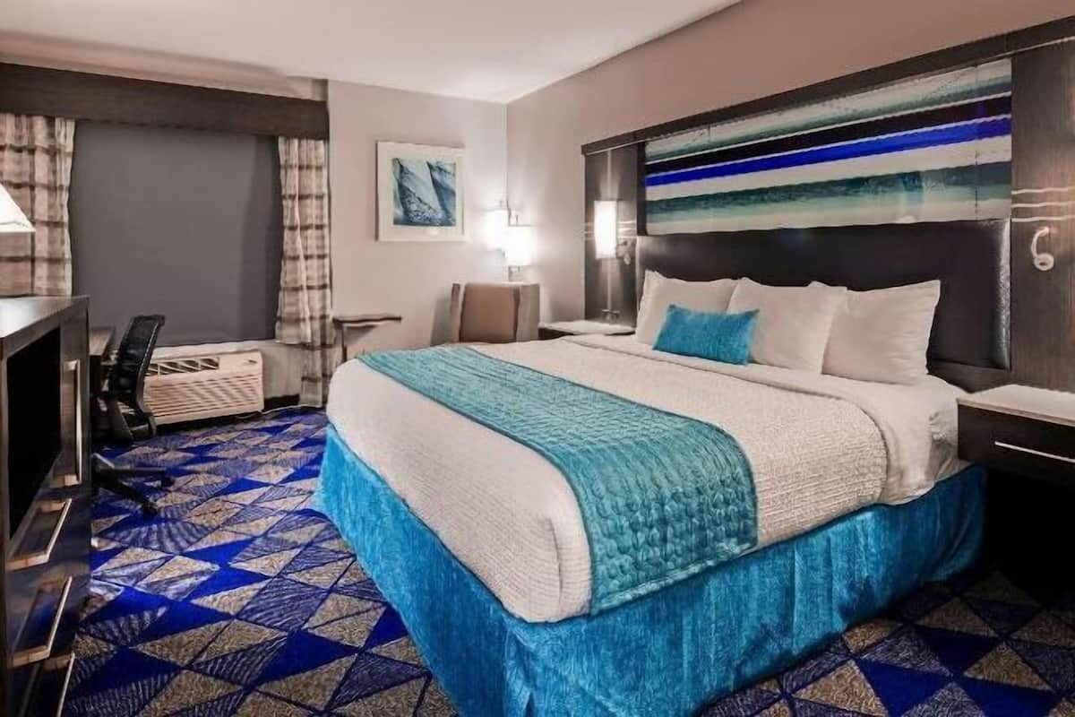 Una scrivania, postazione laptop, tende oscuranti, ferro/asse da stiro