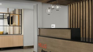 A reception desk with a 'HELLO' sign and 'Annapolis' text, wooden paneling, and hanging pendant lights. - TownePlace Suites by Marriott Annapolis (Annapolis)
