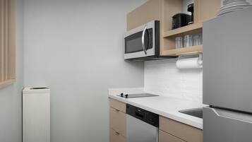 A modern kitchen with a built-in microwave, a dishwasher, and a refrigerator.