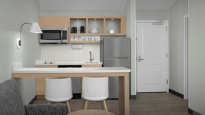 A modern kitchen with a white countertop, stainless steel appliances, and wooden cabinets. - TownePlace Suites by Marriott Annapolis (Annapolis)