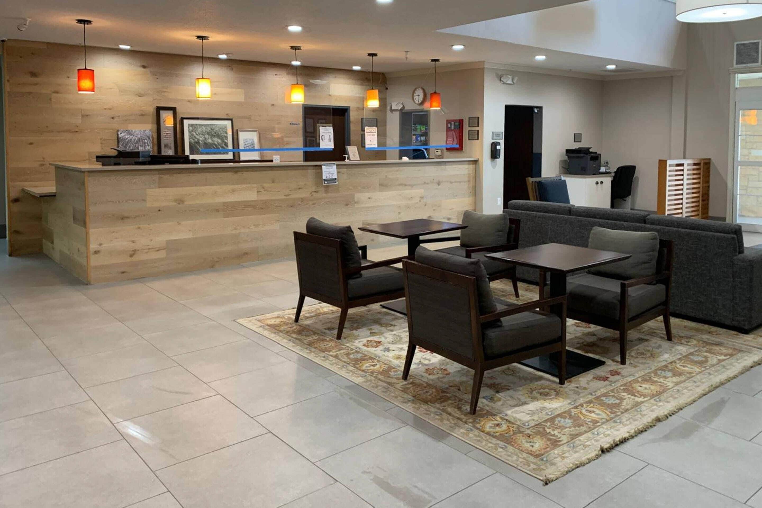 A reception area with a wooden counter, framed pictures, and pendant lighting.