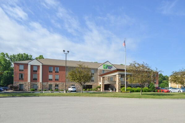 A hotel with a brick facade, a sign indicating it's a Hampton Inn Express, and a flagpole with an American flag.